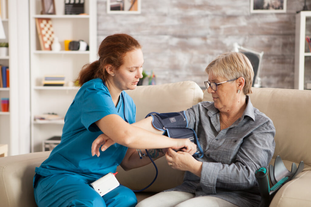 Nurse measuring blood pressure of patient.